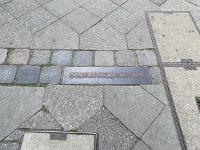A metal marker in concrete: "Berliner Mauer, 1961-1989"