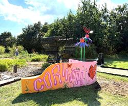 The painted bench by Frank Green and the sculpted flowers by Christi Stidham make a colorful statement in the Corinth Butterfly Garden.