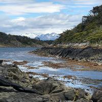 11. Foreground shows a rocky seascape with a view of a glacier in the background.