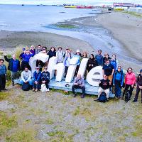 4. A group of people surrounds a large sign that says "Chile."