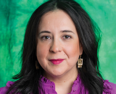 Mónica Salazar is facing forward and smiling. She has dark hair and wears a purple top.