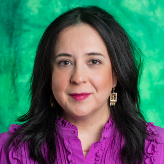 Monica Salazar is facing forward and smiling. She has long dark hair and wears a purple top.