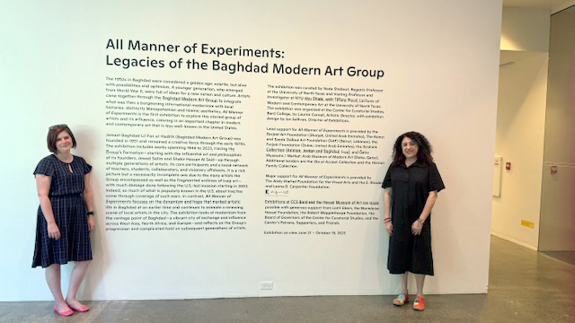 Tiffany Floyd, and Nada Shabout, stand next to the exhibition entrance.