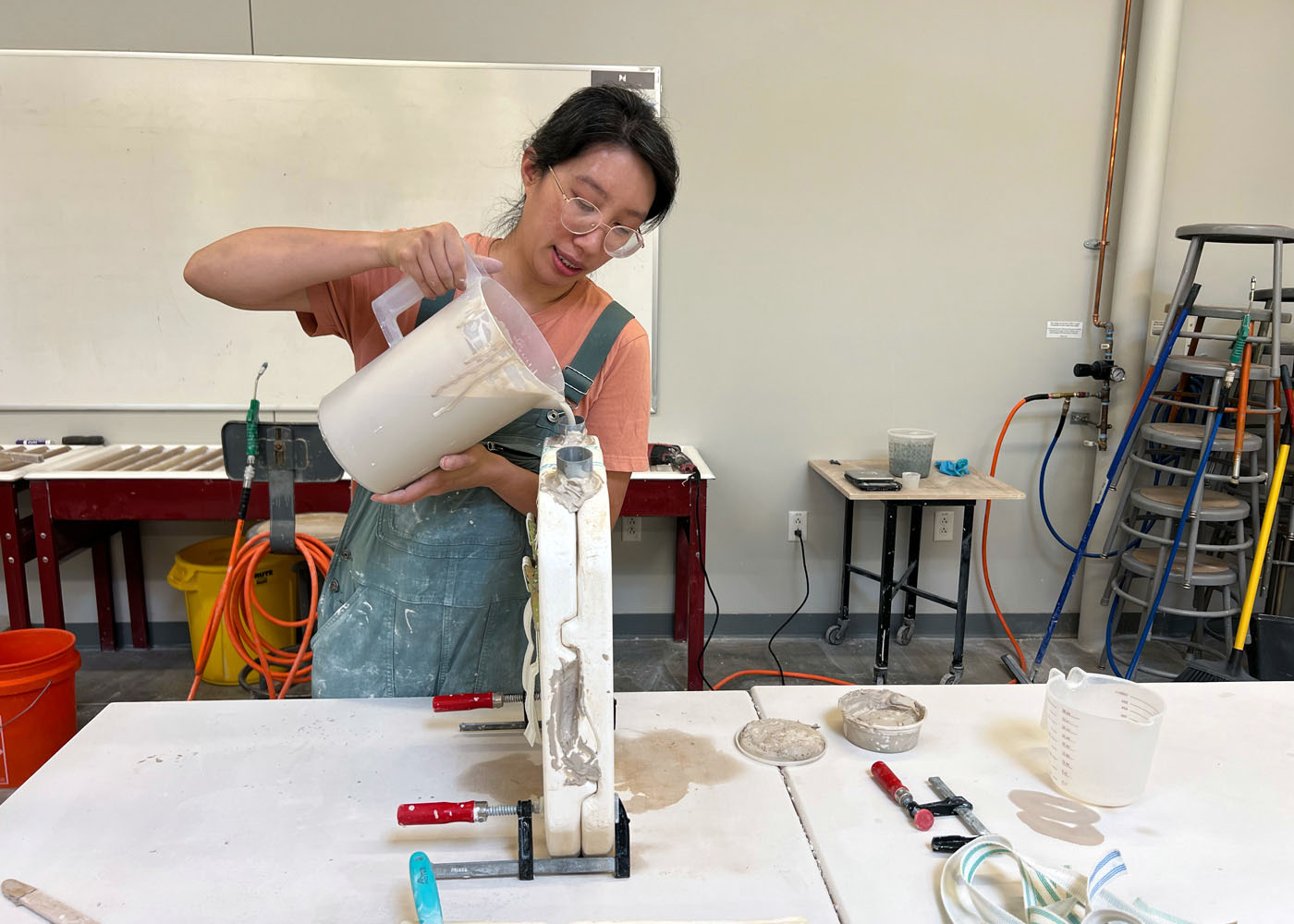 Eliza Au pouring ceramic casting slip into a mold