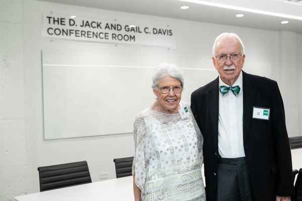 Gail and Jack Davis stand next to each other in the conference room named in their honor.