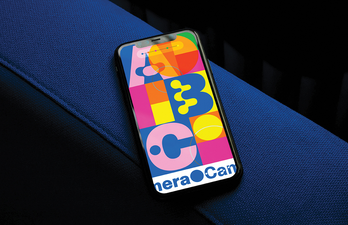 ABC Camera Microsite Image 1: iPhone resting on a blue chair arm, displaying the home screen of the ABC Camera microsite. The bright color palette and structured layout reflect the typeface’s Swiss-inspired attributes, while overlapping elements reference the light traps used in 1960s and 1970s television typography.