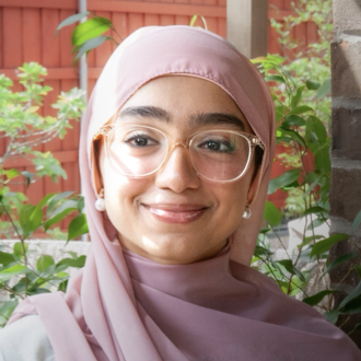 Laiba wearing pink head cover, glasses and smiling