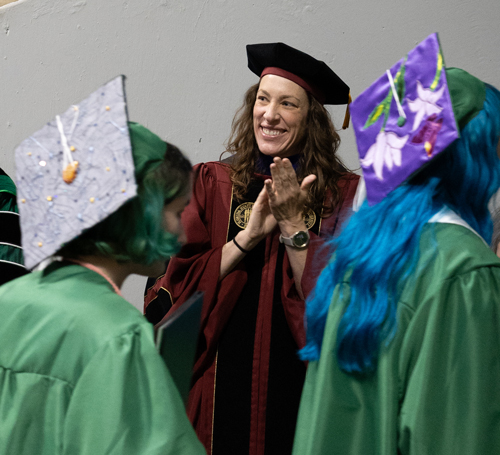Dean Karen Hutzel applauding CVAD graduates at the 2025 commencement ceremony.