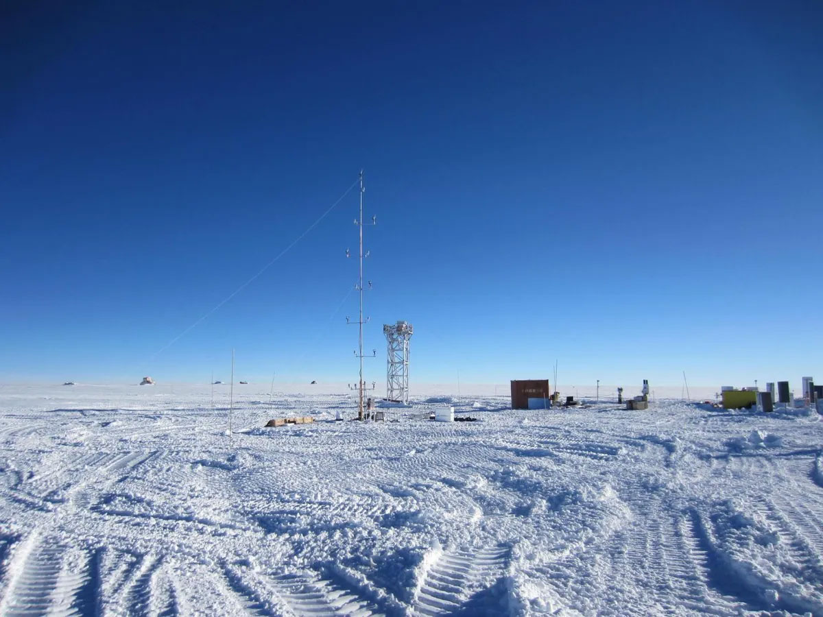 Exterior photo of the astronomical observation station in Antartica showing a large tower and buildings in the snow.