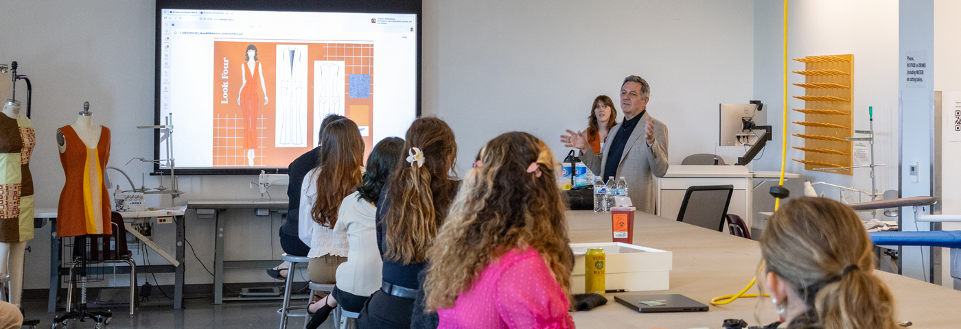 Classroom of fashion designers looking at a slide projection.