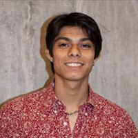 Luis Fraga smiling, looking forward, red shirt