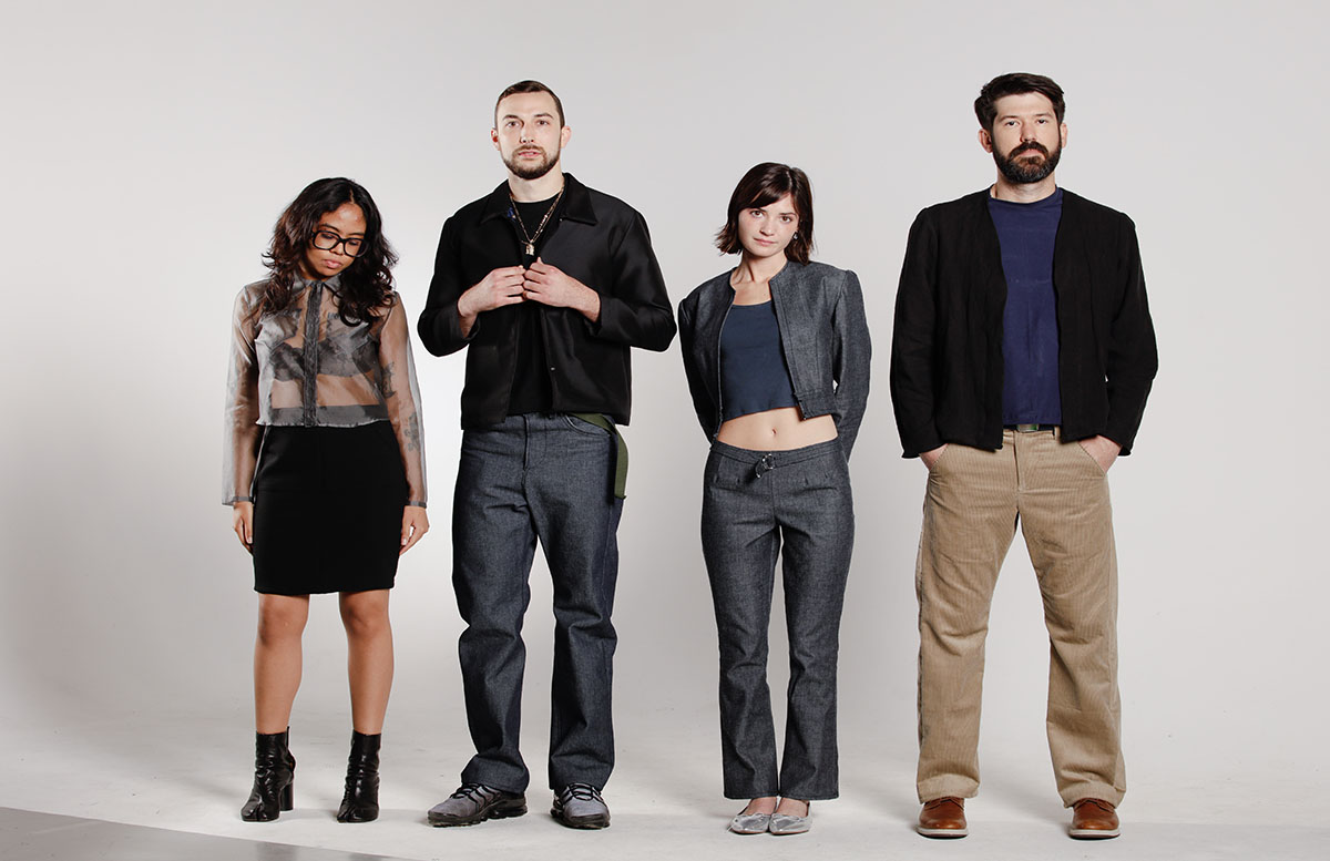 Four models stand together wearing looks created by the designer. 