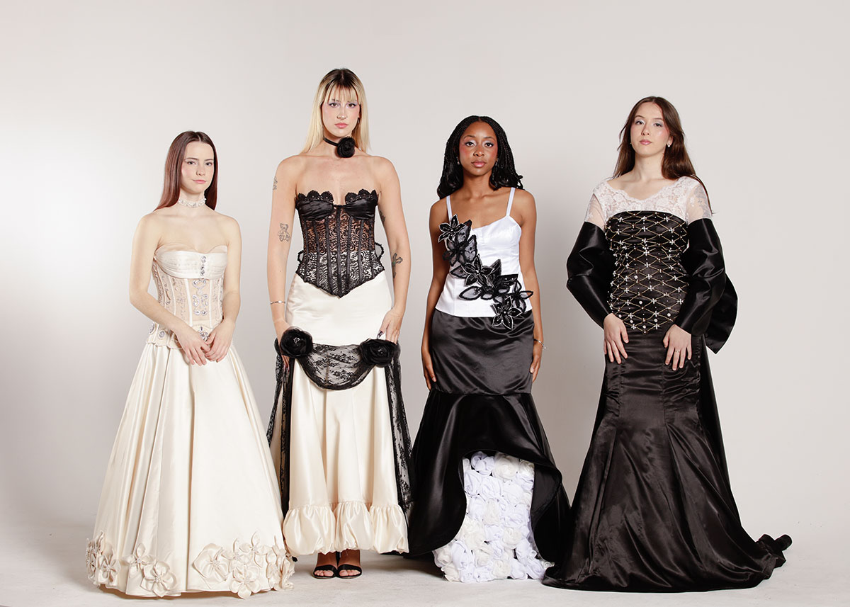 Four models in cream, black, and white evening gowns adorned with intricate beading, floral accents, lace, and structured silhouettes inspired by feminine fantasy.