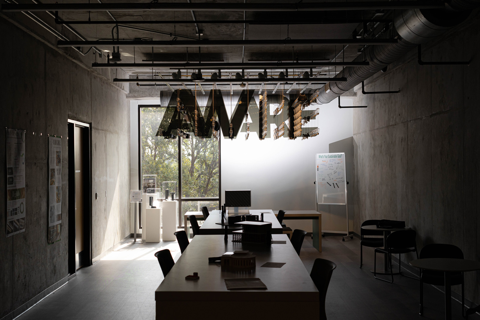 A lighting fixture that spells AWARE hangs in the Second Floor of the Art Building