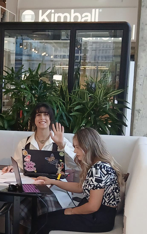 Two students at a table in front of the Kimball store.