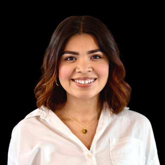 Janet is facing forward and smiling. She has medium-length dark hair and wears a white top.