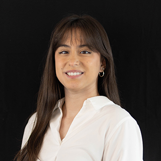 Franchesca is facing forward and smiling. She has long, dark hair and wears a white top.