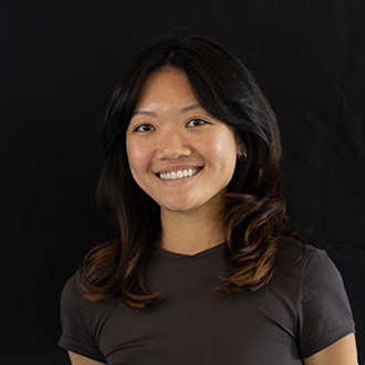 Melissa is facing forward and smiling. She has medium-length dark hair and wears a black top.