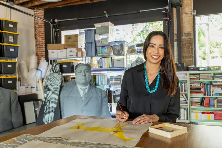 Wendy Red Star in her studio facing forward and smiling.