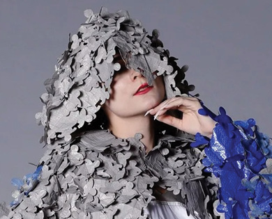 Model wearing a blue, white and gray hooded garment.