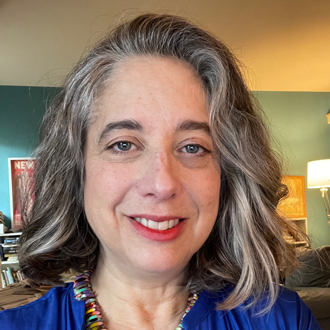 Paula is facing forward and smiling.