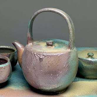 Brown and green ceramic teapot.