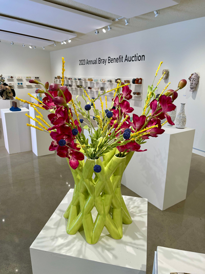 Green vase by Brooks Oliver with maroon flowers