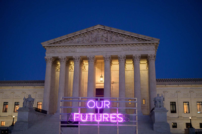 Supreme Court Bldg with "our futures" in pink neon light