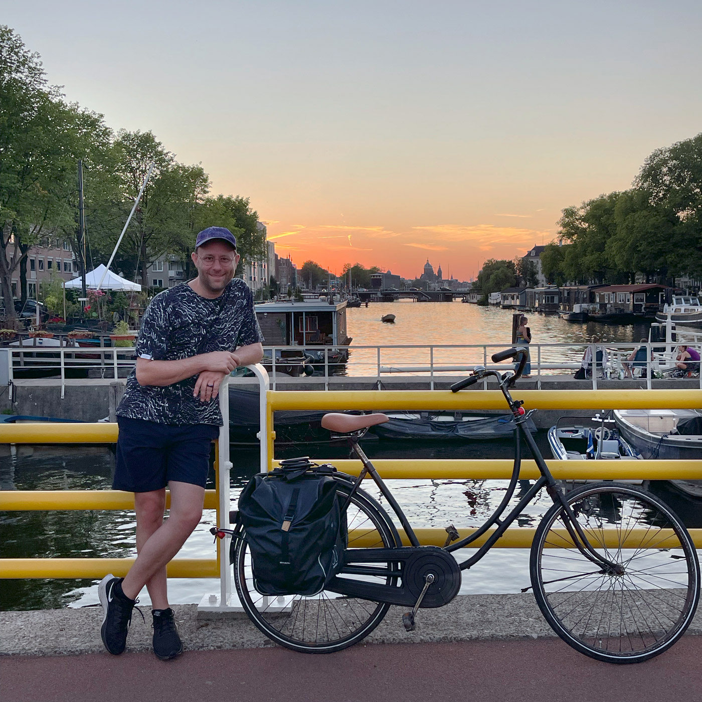 Chris Meerdo leaning on a bicycle against the background of the Amstel River,