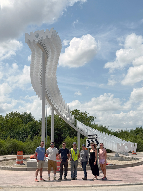 People standing in front of a large white metal structure
