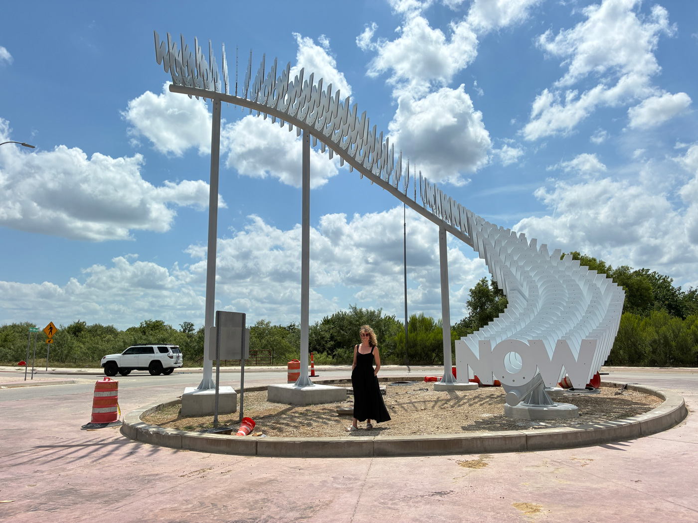 Alicia Eggert stands in front of the "Now" installation in a Forth Worth city roundabout.