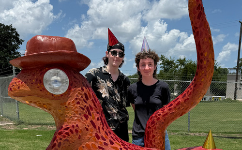 Frank Green, left, and Rachel Brigman pose in behind their "Lewis the Lizard" sculpture