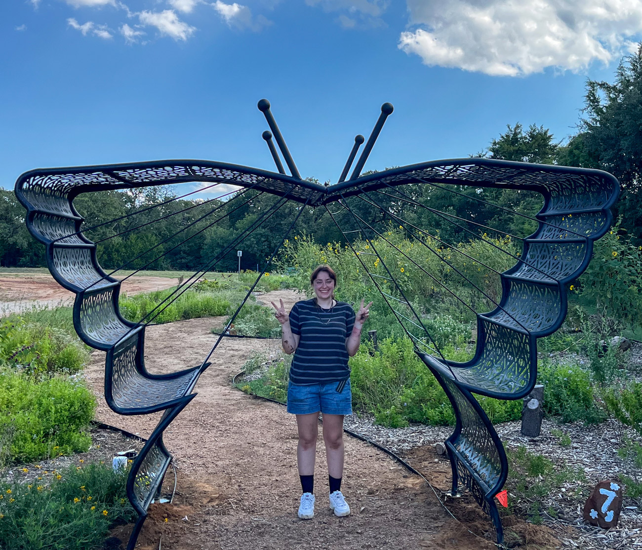 Brooke Thompson standing under the trellis she created.