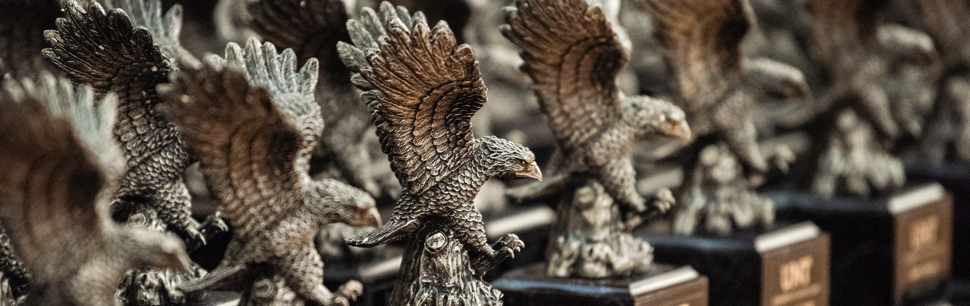 Small, brown eagle statues lined up on a table