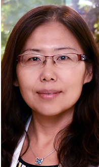 Xin is facing forward. She has long dark hair, wears glasses and a white top.