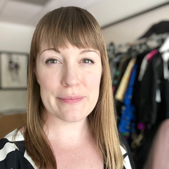 Annette Becker facing forward with garments in the background.