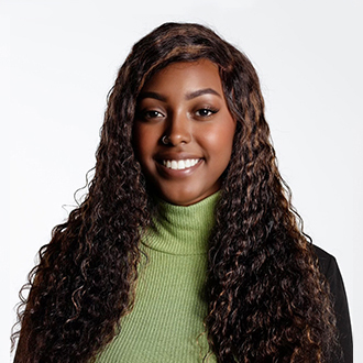 Madison facing forward, smiling, long wavy brown hair, green shirt