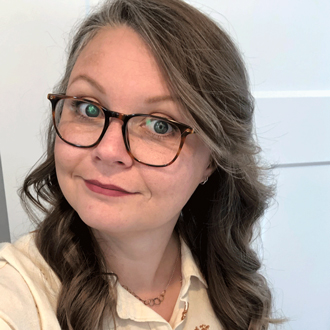 Bevin Butler, long wavy brown hair, glasses, light yellow shirt