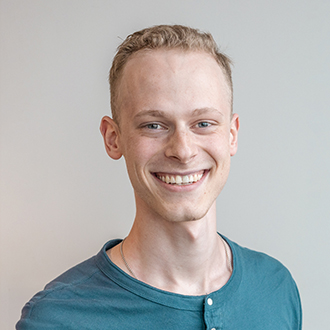 Keaton facing forward, smiling, brown hair, blue shirt