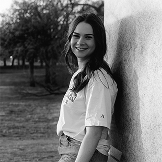 Jennifer Dooley, portrait, black and white, standing against a wall