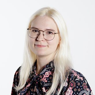 Erin facing forward, smiling, blonde hair, floral-patterned shirt