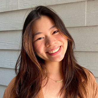 Headshot of Ranee Leider smiling in front of brick wall.