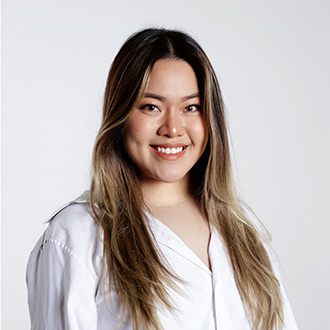 Grayce facing forward, smiling, long brown and blonde hair, white shirt