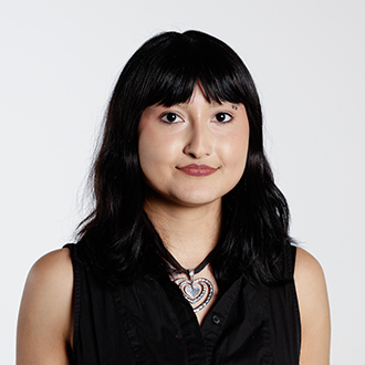 Elaine facing forward, black hair, black sleeveless top, hear shaped necklace  