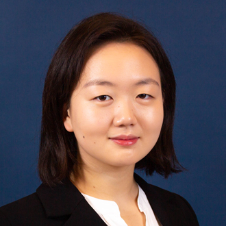 Jae-Eun smiling at the camera, head-and-shoulders, black hair, dark blue background.