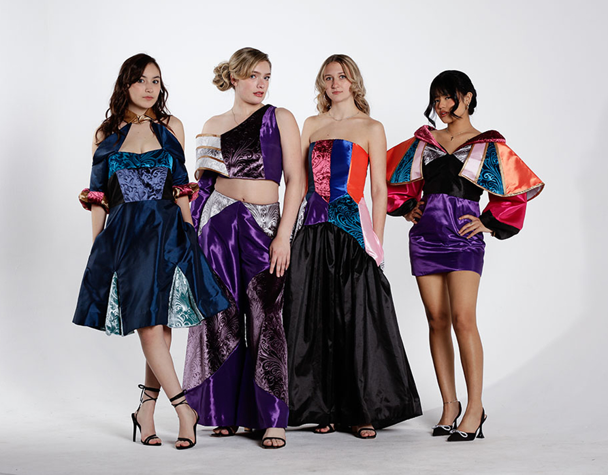 Four models in colorful dresses and a top and pant combination standing in front of a white background. 