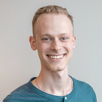 Keaton smiling, short red hair, blue shirt