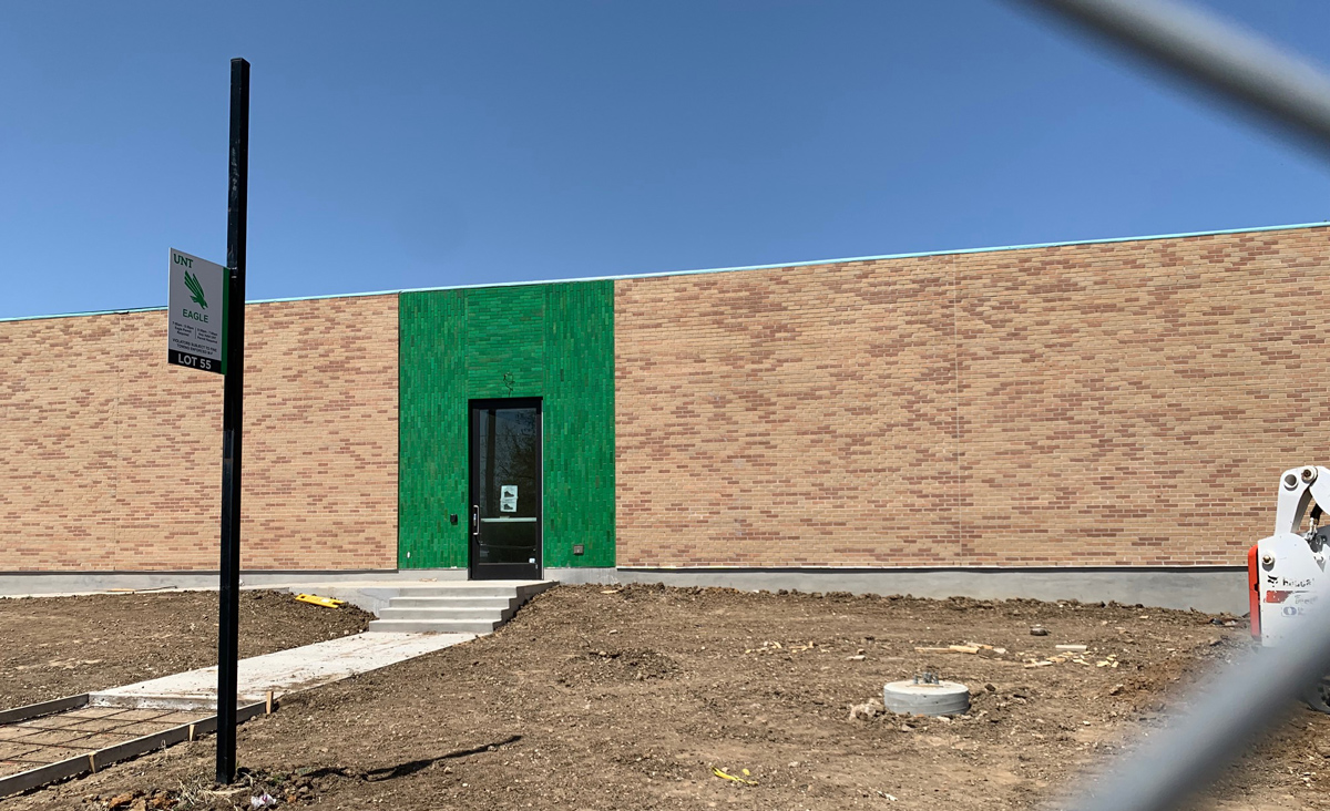 South facade of the new Art Annex, beige brick wall with green tiles around the door