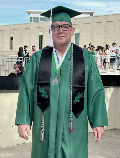 Jerry wearing his graduation cap and gown in May 2023