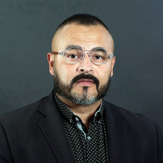 Walter Barraza head-and-shoulders portrait, wearing glasses, black hair and beard, round glasses